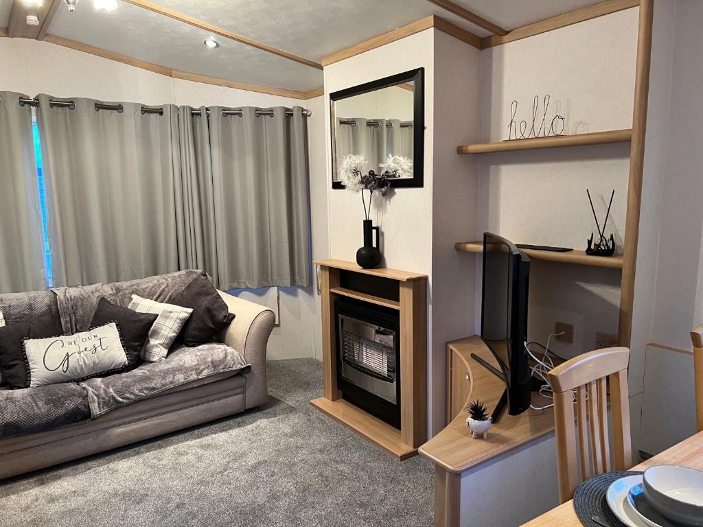 a living room with a couch and a television at Coastal Caravan Holidays - Goldfinch 22 in Withernsea