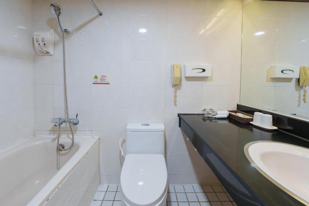 a bathroom with a toilet and a sink at Oriental Hotel in Tainan