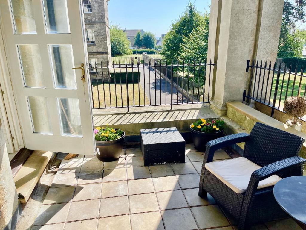 un patio con una puerta, sillas y una mesa en St Andrews Apartments en Maidstone