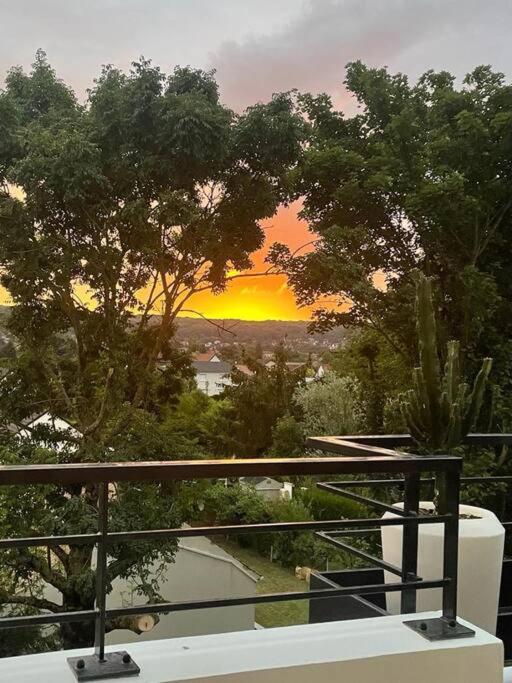 d'un balcon offrant une vue sur le coucher du soleil. dans l'établissement T4 Chaleureux et moderne, à Saint-Leu-la-Forêt