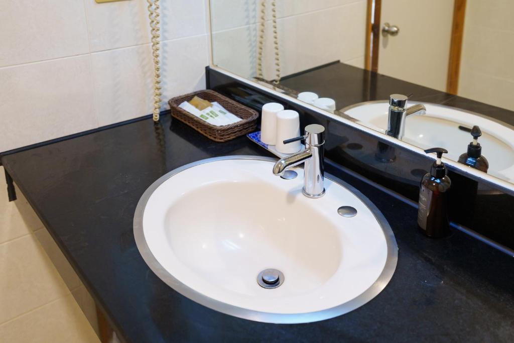 a bathroom counter with a sink and a mirror at Oriental Hotel in Tainan