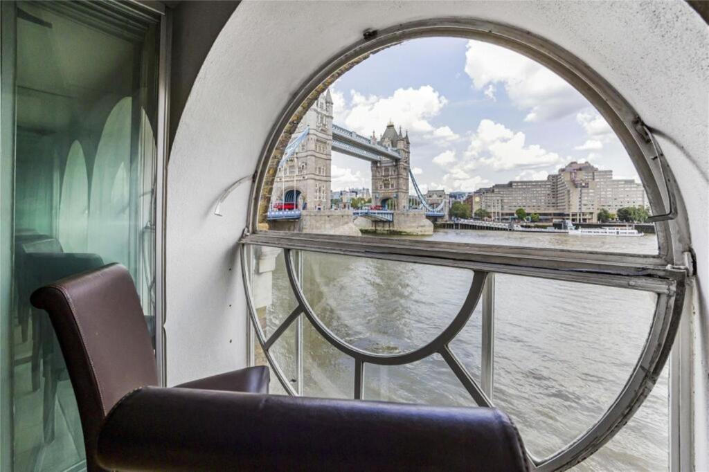 een raam op een boot met uitzicht op de rivier bij Subpenthouse sleeps 6, Stunning views of Tower Bridge! in Londen