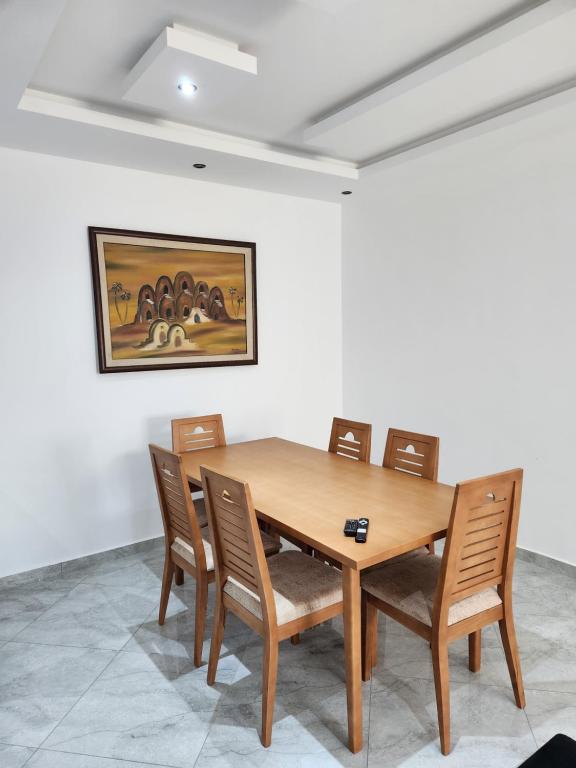 a dining room with a wooden table and chairs at résidence el yassamine 17 in Bizerte