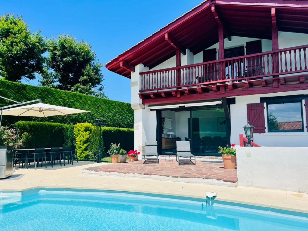 a house with a swimming pool in front of a house at Villa Goxoki in Urrugne