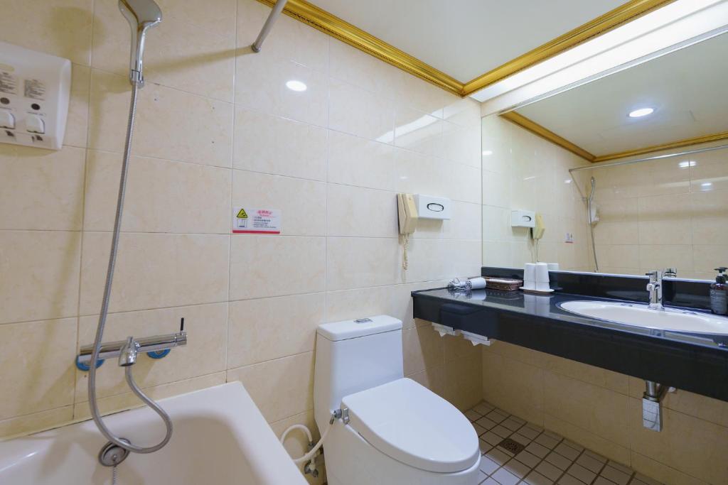 a bathroom with a toilet and a sink at Oriental Hotel in Tainan