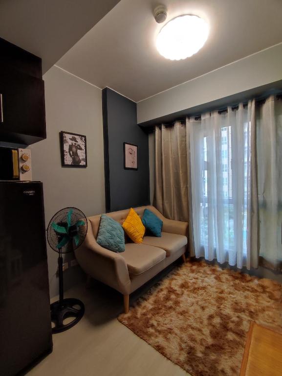 ein Wohnzimmer mit einem Sofa und einem Fenster in der Unterkunft RC Staycation in Manila