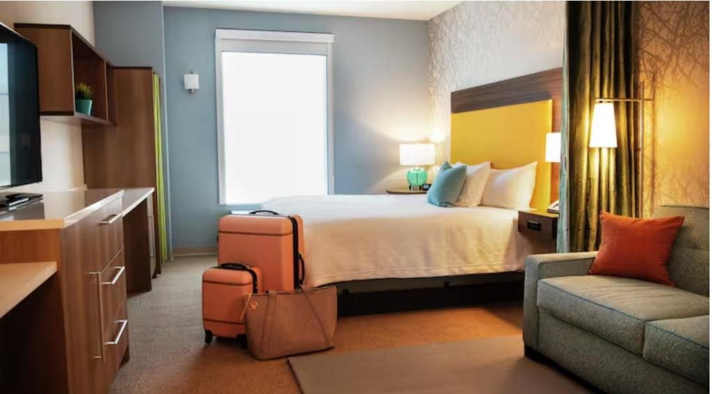 a hotel room with a bed and a couch at Home2 Suites By Hilton Indianapolis North At Intech Park in Indianapolis