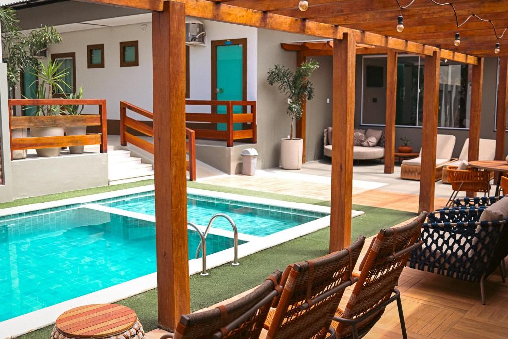 una piscina in una casa con sedie e tavolo di Atalaia VIP Praia Hotel a Salinópolis
