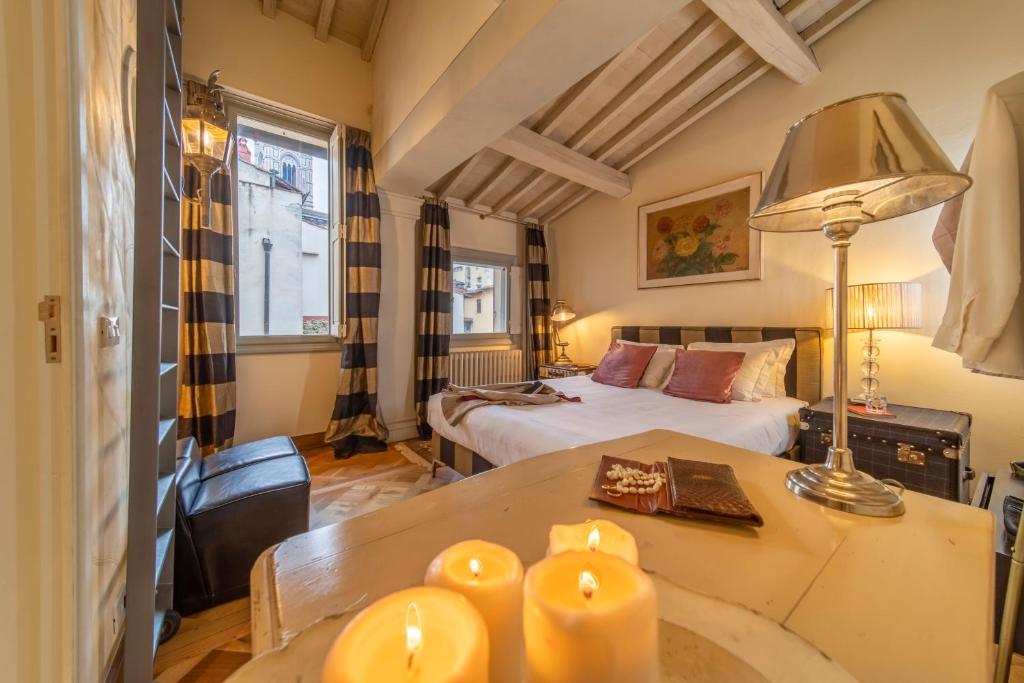 1 dormitorio con 1 cama y 1 mesa con velas en L'Alcova di Giotto, en Florencia