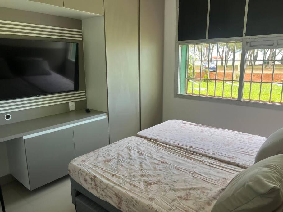 a bedroom with a bed and a flat screen tv at Apartamento vista pro mar in Tramandaí