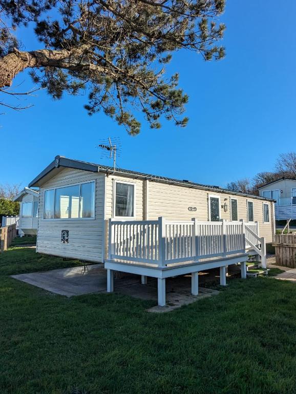 a mobile home with a porch and a bench at Relaxing Holiday Home Chickerell View Littlesea Haven in Weymouth