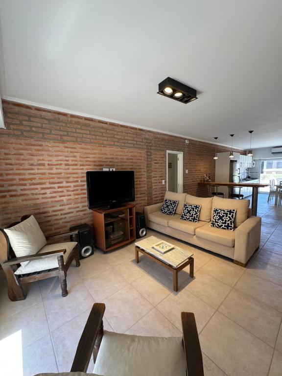 sala de estar con 2 sofás y TV en Casa de playa en Balneario Claromecó