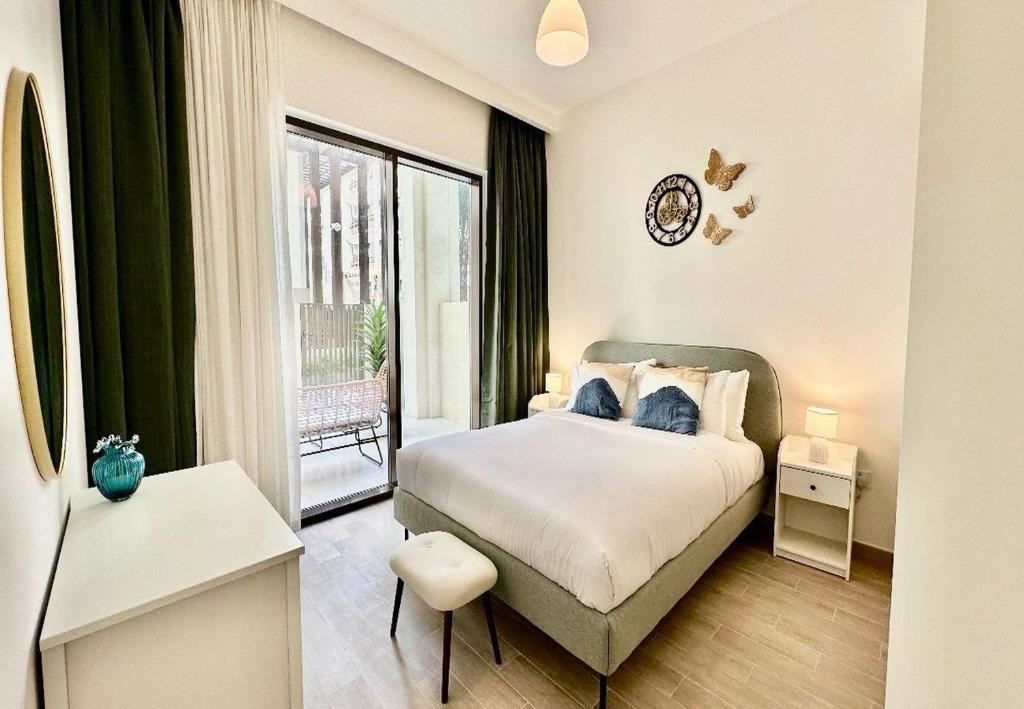 a bedroom with a bed and a large window at EasyGo - Sunset Creek 1 Bedroom in Dubai