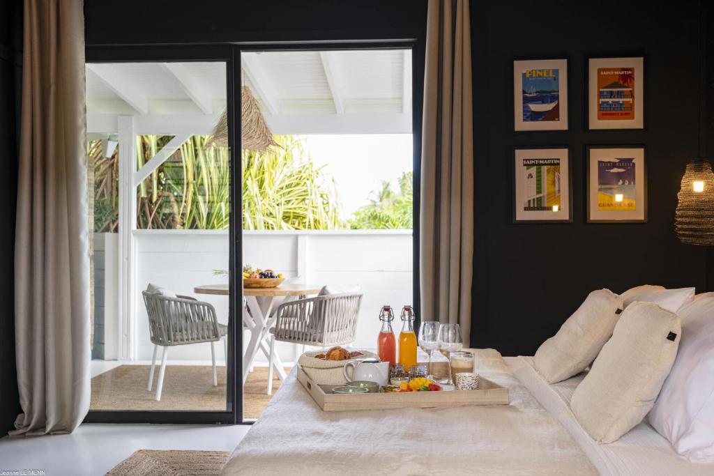 een woonkamer met een bank en een dienblad met eten bij Pomme Cannelle - Luxury Suites & Spa in Saint Martin
