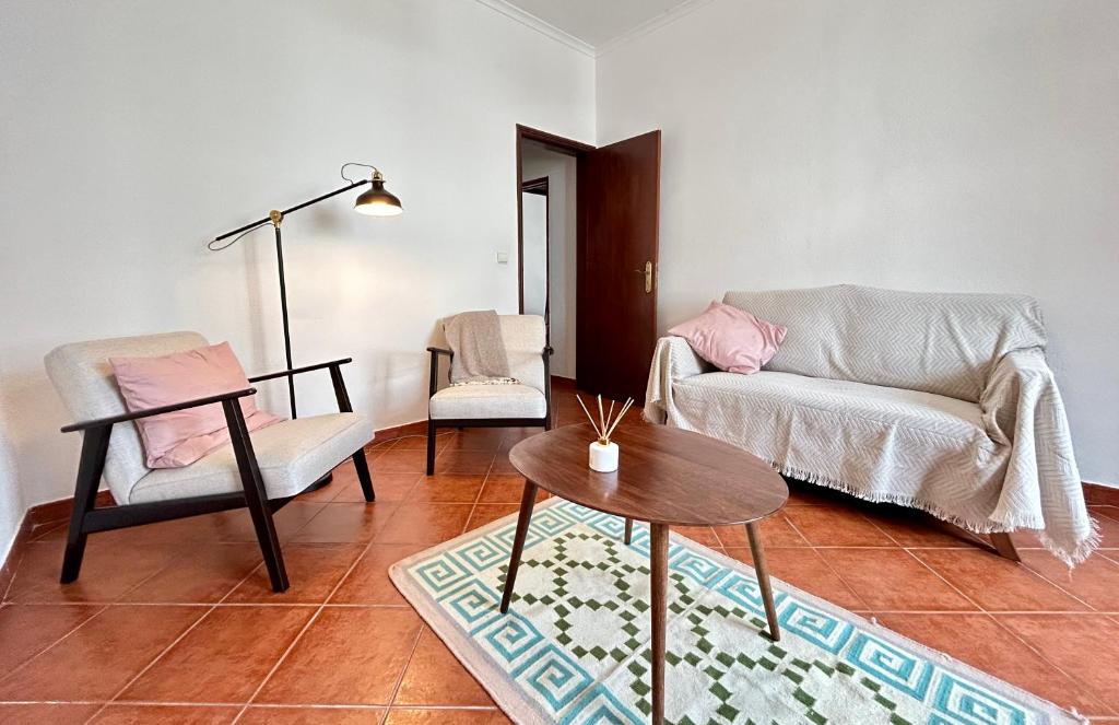 Portuguese village apartment - Casa Martins No.54 في Freiria: غرفة معيشة مع كرسيين وطاولة