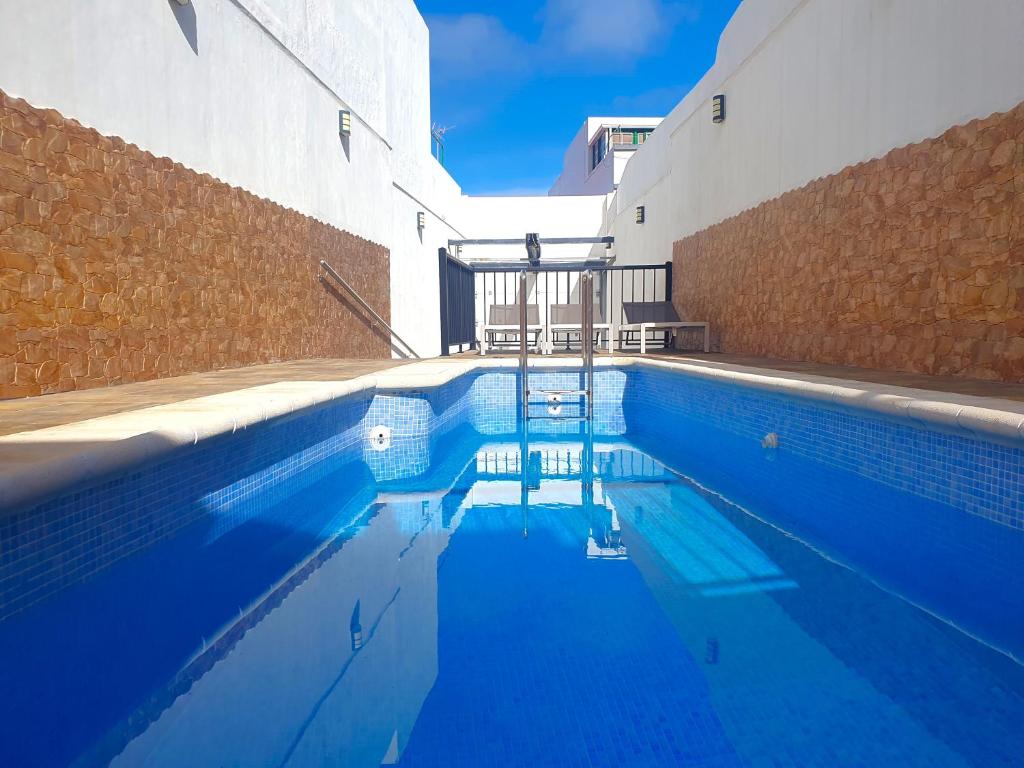una piscina de agua azul frente a un edificio en San Clemente with Pool & Wi-fi, en Caleta de Interián