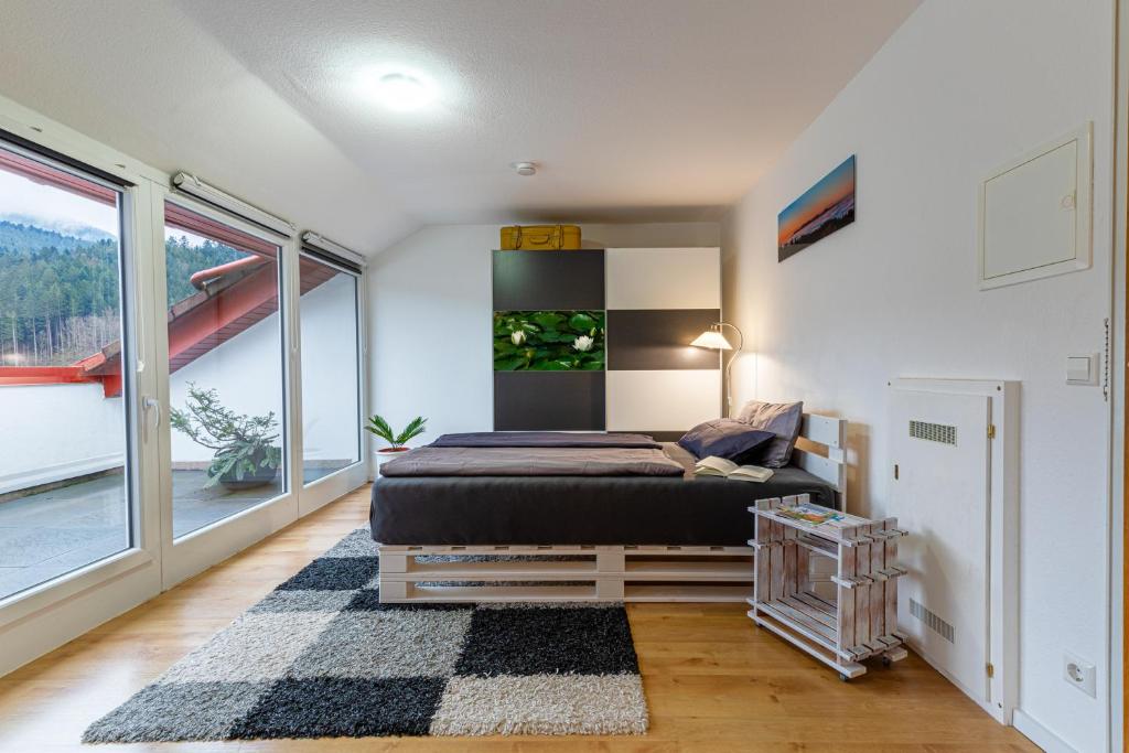 ein Schlafzimmer mit einem Bett und einem großen Fenster in der Unterkunft Sagenhafter Ausblick in Bad Peterstal-Griesbach