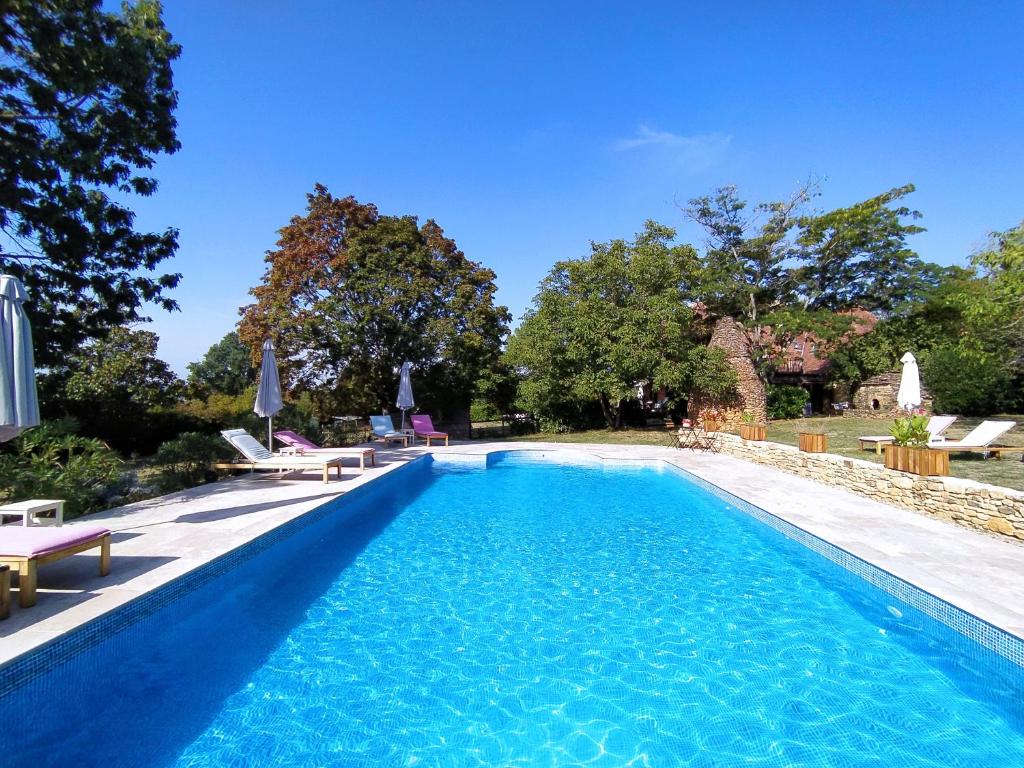 ein Swimmingpool mit blauem Wasser in einem Hof in der Unterkunft La Borie du Cambord - Gîtes et Chambres d'hôtes in Sarlat-la-Canéda