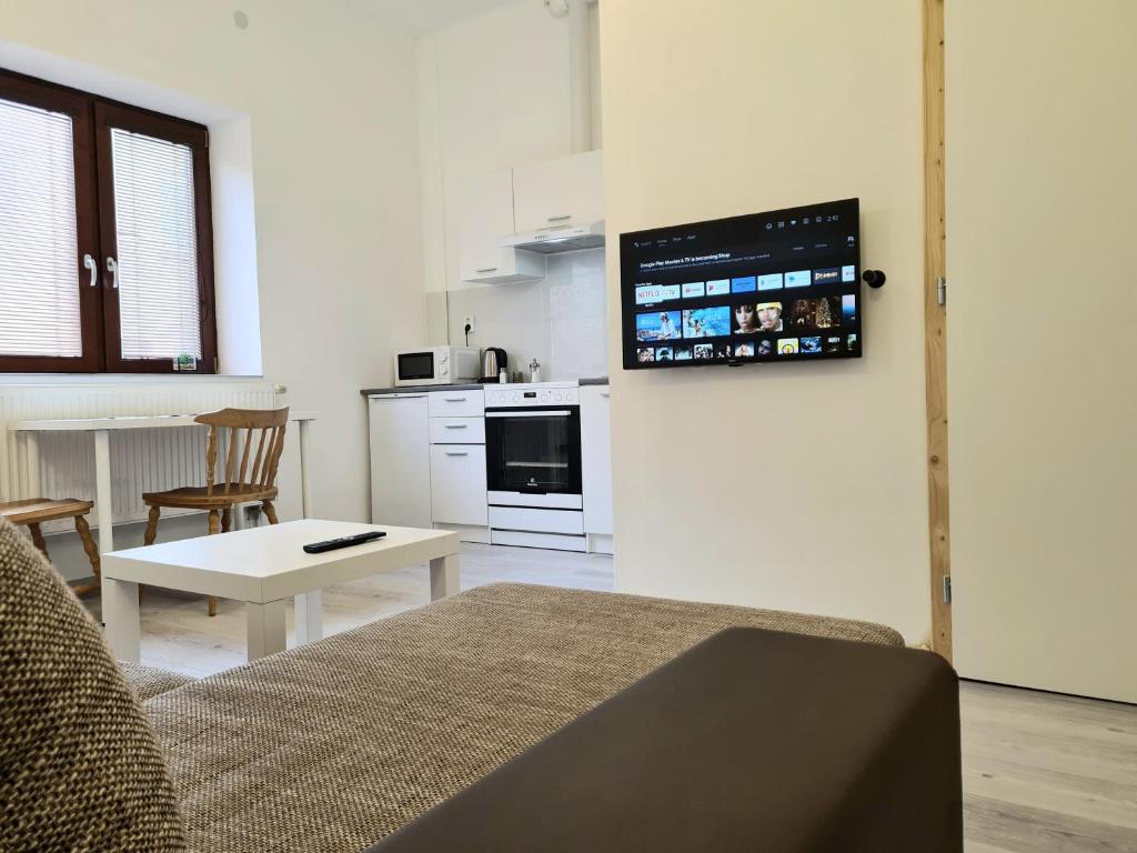 a living room with a couch and a table and a kitchen at Brno apartment in Brno