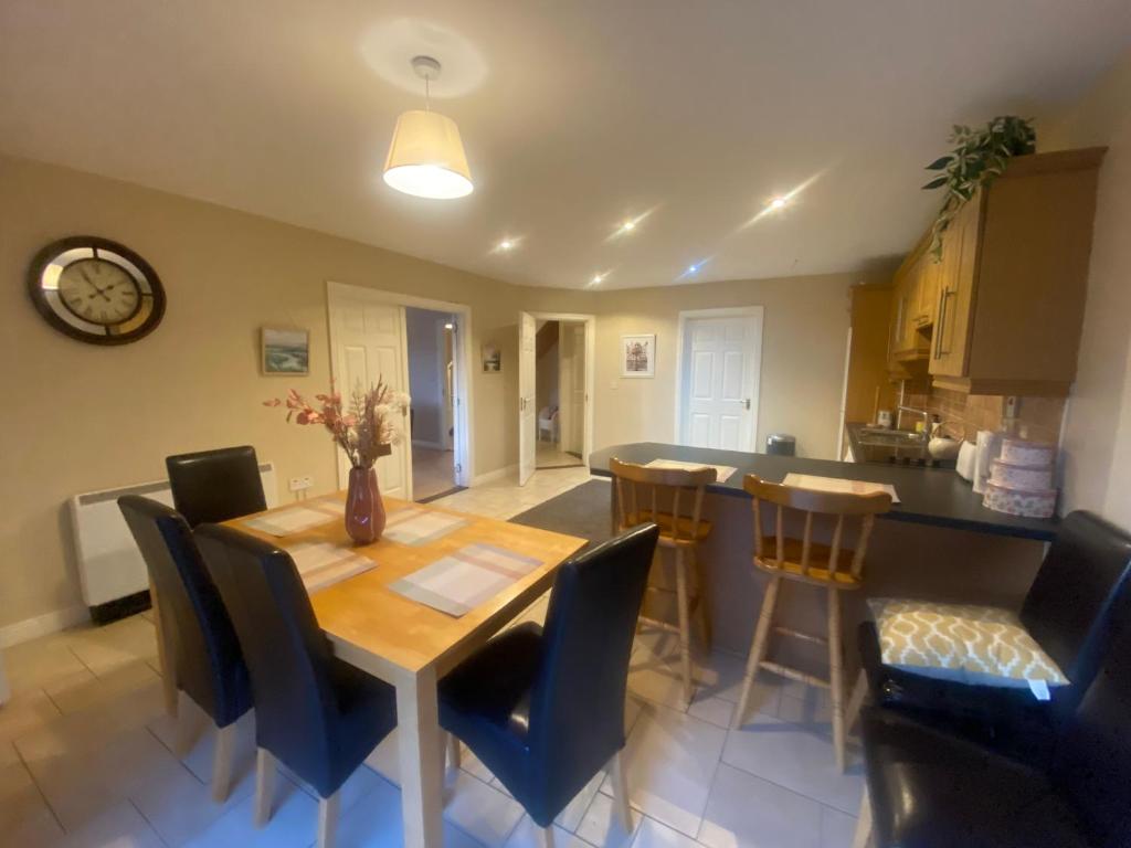 cocina y comedor con mesa de madera y sillas en Luxury Town House-Apartment Carrick-on-shannon, en Carrick on Shannon