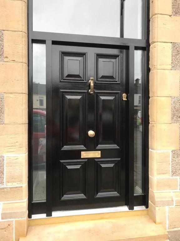 a black door on a building at The Bank Apartment Irvinestown in Irvinestown