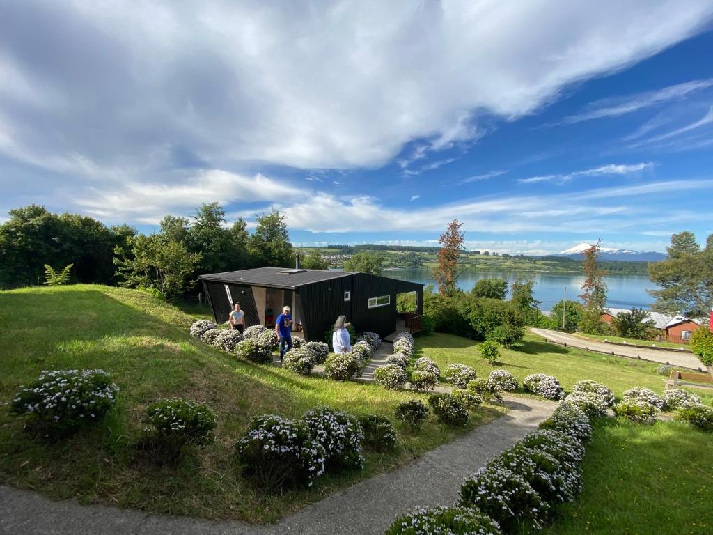 a group of people standing in front of a black house at Amukan Lodge in Panguipulli