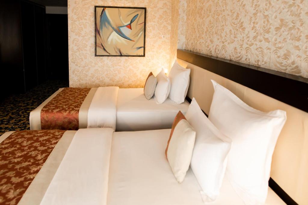 Postel nebo postele na pokoji v ubytování Malak Regency Hotel