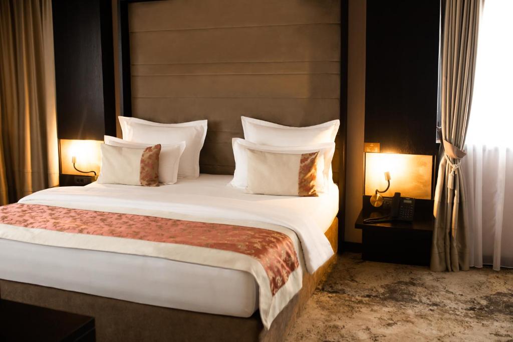 Postel nebo postele na pokoji v ubytování Malak Regency Hotel