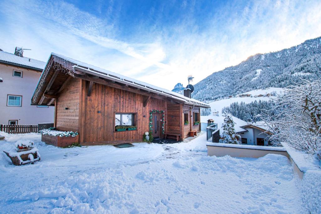 a wooden cabin in the snow with snow covered at Chalet Berna in Ortisei