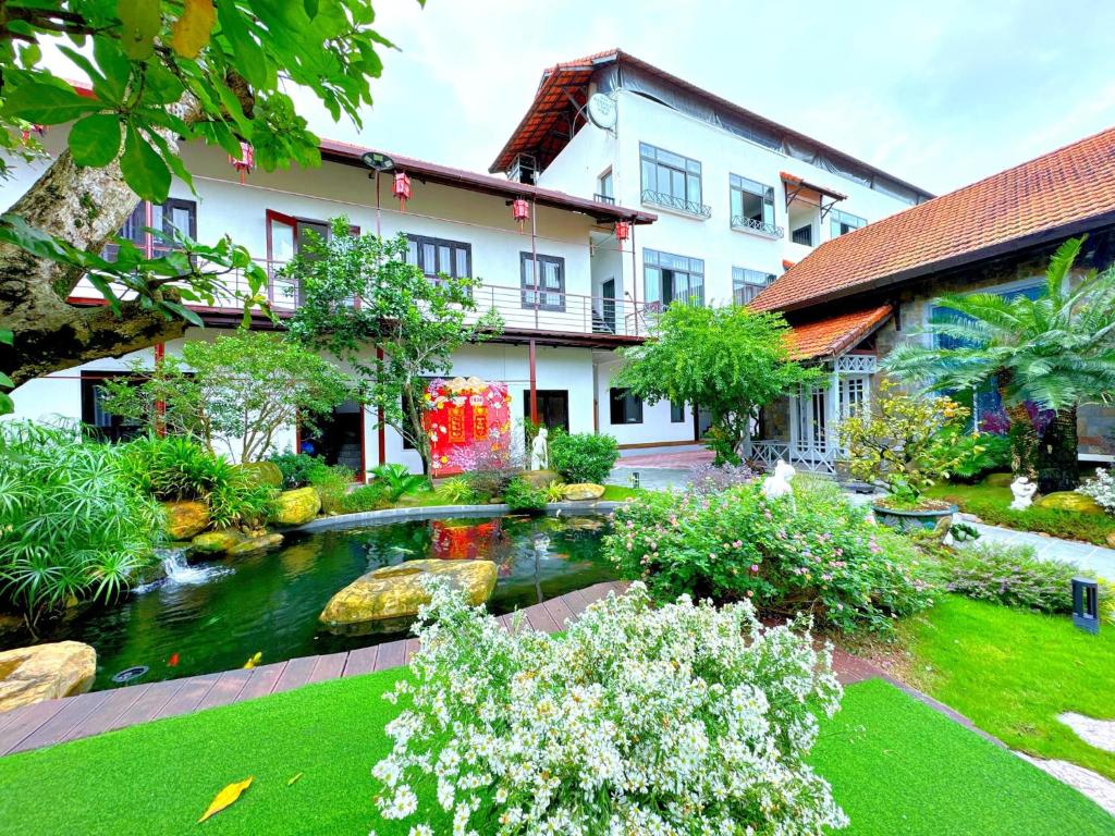 順化的住宿－Golden Star Villa Hue，一座花园,在一座建筑前设有一个池塘