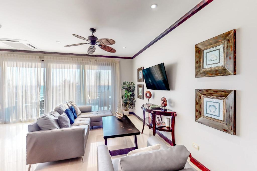 a living room with a couch and a ceiling fan at Diamante del Sol 402S in Jacó