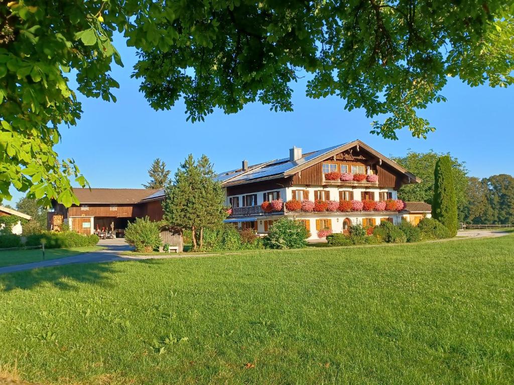 a large house with a grass field in front of it at Ferienwohnung Oberlinner in Miesbach