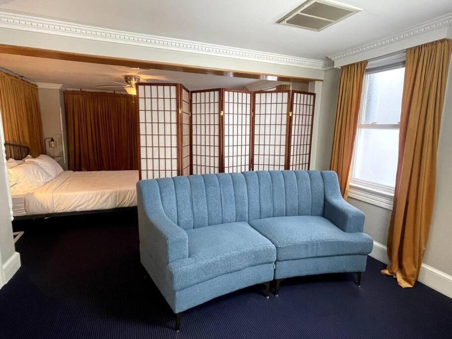 a living room with a blue couch and a bed at Large studio apartment steps from the US Capitol! in Washington