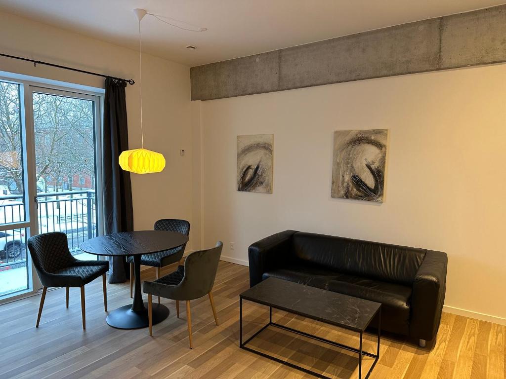 ein Wohnzimmer mit einem Sofa und einem Tisch in der Unterkunft City apartment Dæmningen Vejle in Vejle