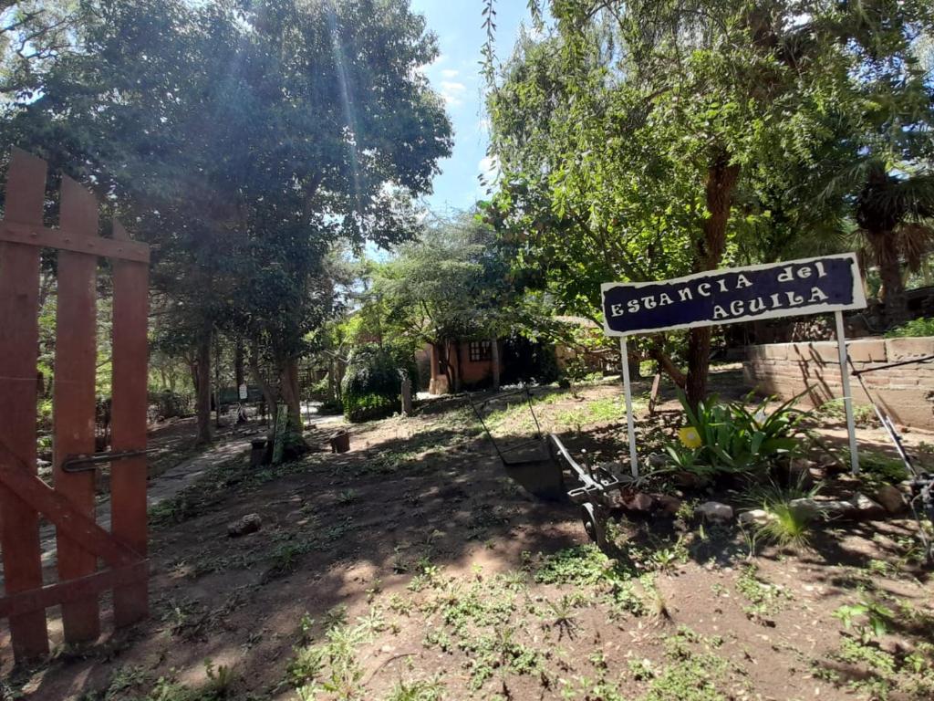 una señal en un patio junto a una valla en Complejo de Cabañas Estancia Del Águila en Mina Clavero
