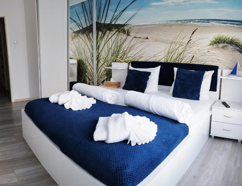 - une chambre avec un lit doté d'oreillers blancs et une plage dans l'établissement APARTAMENT MARI Polanki Park, à Kołobrzeg