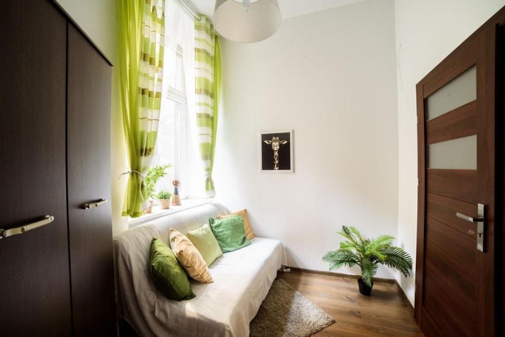 a window seat in a living room with green curtains at Szlak Old Town in Krakow