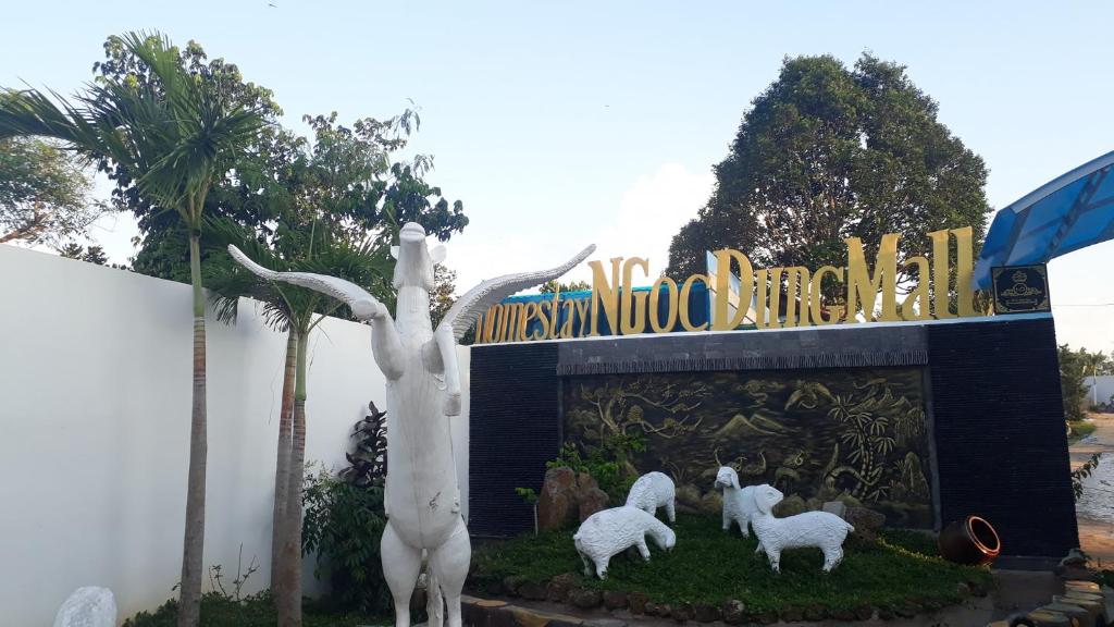 ein Schild mit drei weißen Schafstatuen vor einem Schild in der Unterkunft Ngọc Dung Mall Homestay in Tân Phú