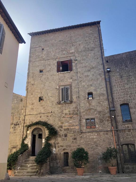 a large stone building with a door and a window at Torre degli Alessandri in Viterbo