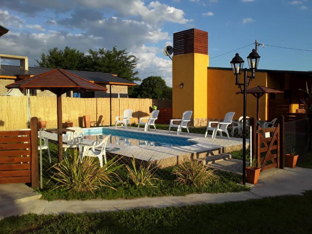 een zwembad met stoelen en een tafel en parasol bij Clara Rosa in San Ignacio