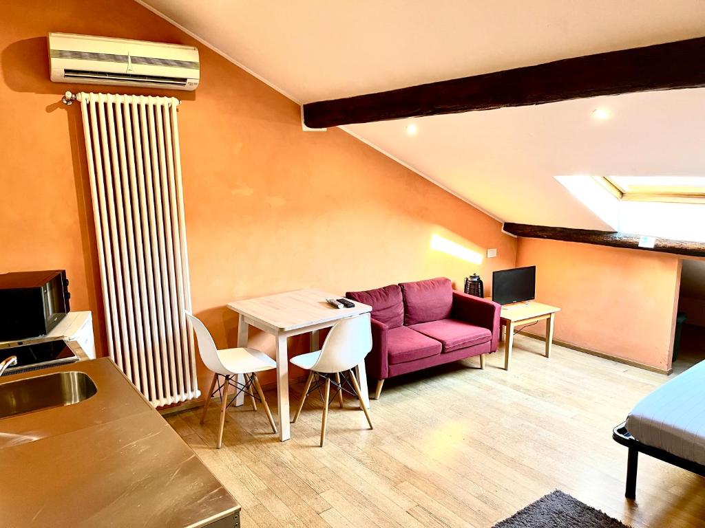 ein Wohnzimmer mit einem lila Sofa und einem Tisch in der Unterkunft Il Nido 14 in Mailand