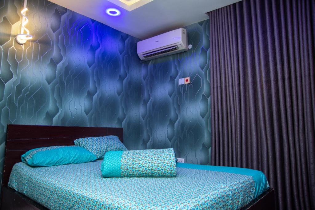 a bedroom with a bed and a wall at Haffy Executive Hotels and Suite in Uyo