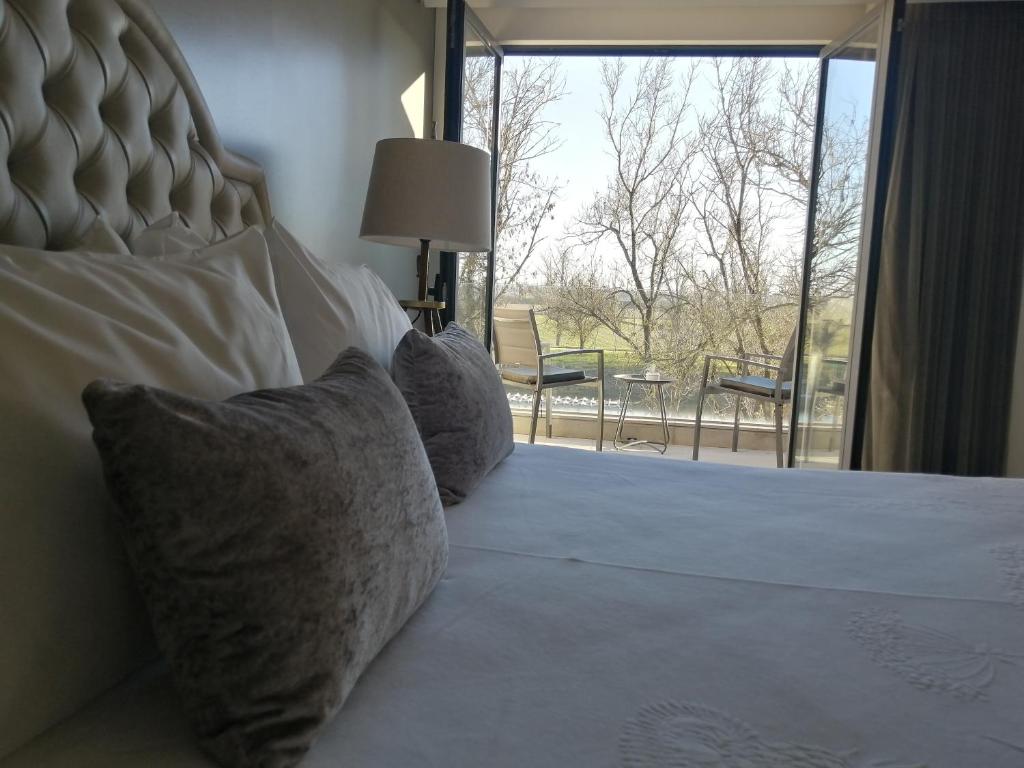 una camera da letto con letto, cuscini e finestra di Casa do Rio Sorraia a Coruche