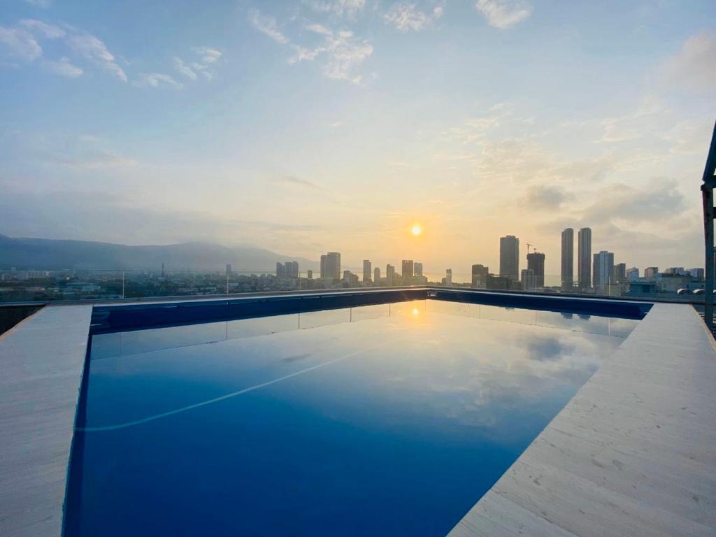 a swimming pool on top of a building with a city skyline at NATURE Hotel By K D H in Da Nang