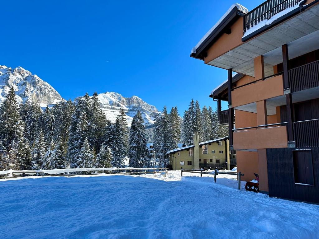 a snow covered yard in front of a building at Bilocale Rio Falzè - Serafini in Madonna di Campiglio