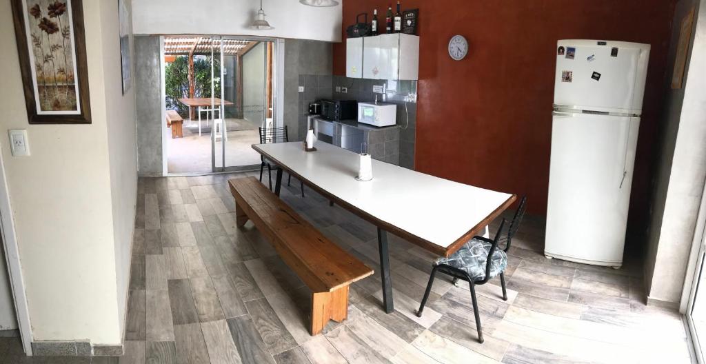 una cucina con un tavolo, una panca e un frigorifero di Verona Hostel a Necochea