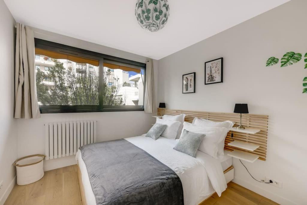 ein weißes Schlafzimmer mit einem Bett und einem Fenster in der Unterkunft Espace Champerret - 1 Bedroom 4 people in Levallois-Perret