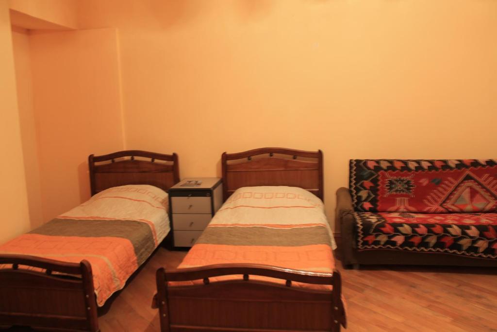 two beds and a couch in a room at Hostel Old City Sololaki in Tbilisi City