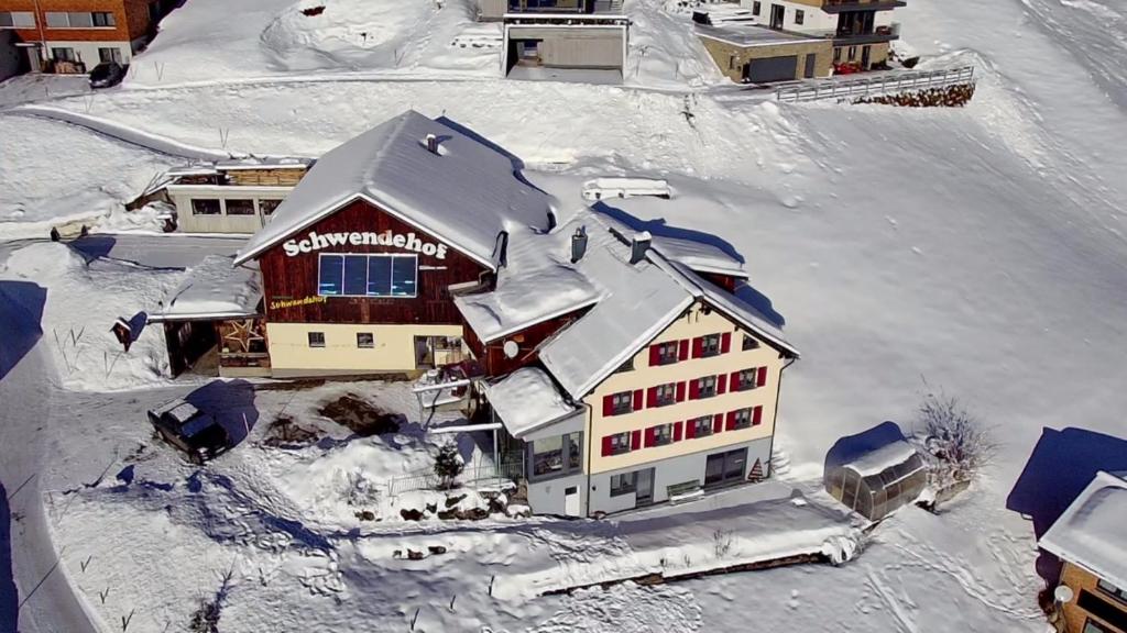 een luchtzicht op een huis bedekt met sneeuw bij Ferienhaus Schwendehof in Fontanella