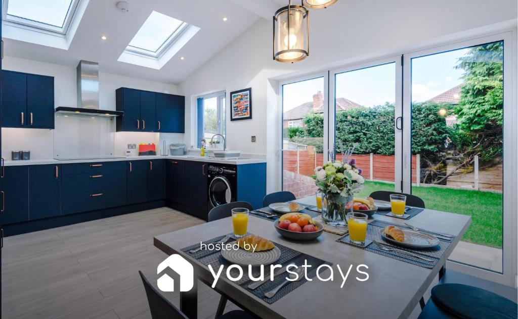 a kitchen and dining room with a table with fruit on it at Sandileigh Drive by YourStays in Altrincham